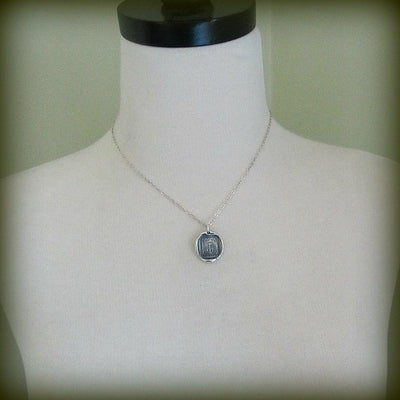 Our anchor wax seal necklace around a mannequin.