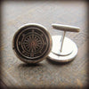 Two Compass Cuff Links displayed on a table