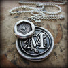 A personalized wax seal medallion with a smaller medallion attached.