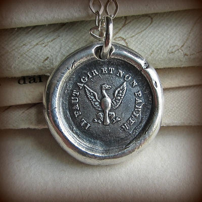 An eagle wax seal medallion on a chain.