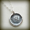 Wax seal necklace with an eagle on it with a white background.