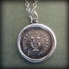 Harp french wax seal with silver chain and green background.