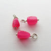 Three hot pink chalcedony nugget charms.