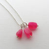 Three hot pink chalcedony nugget charms attached to a stainless steel chain.