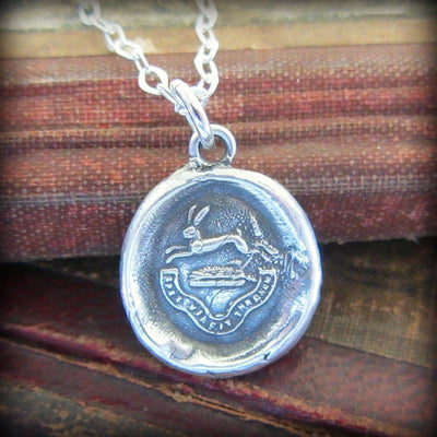 Rabbit wax seal crest necklace with the phrase hope conquers all.