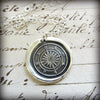 Compass Wax Seal with a silver chain lying on old english script