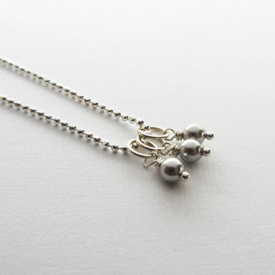 Three swarovski silver pearls on a chain to make a necklace.